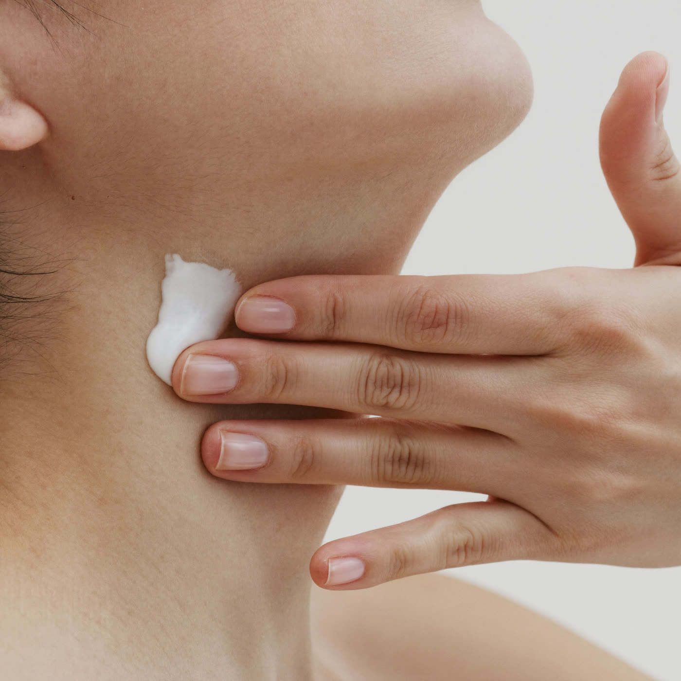 Applying the moisturiser upward along the neck